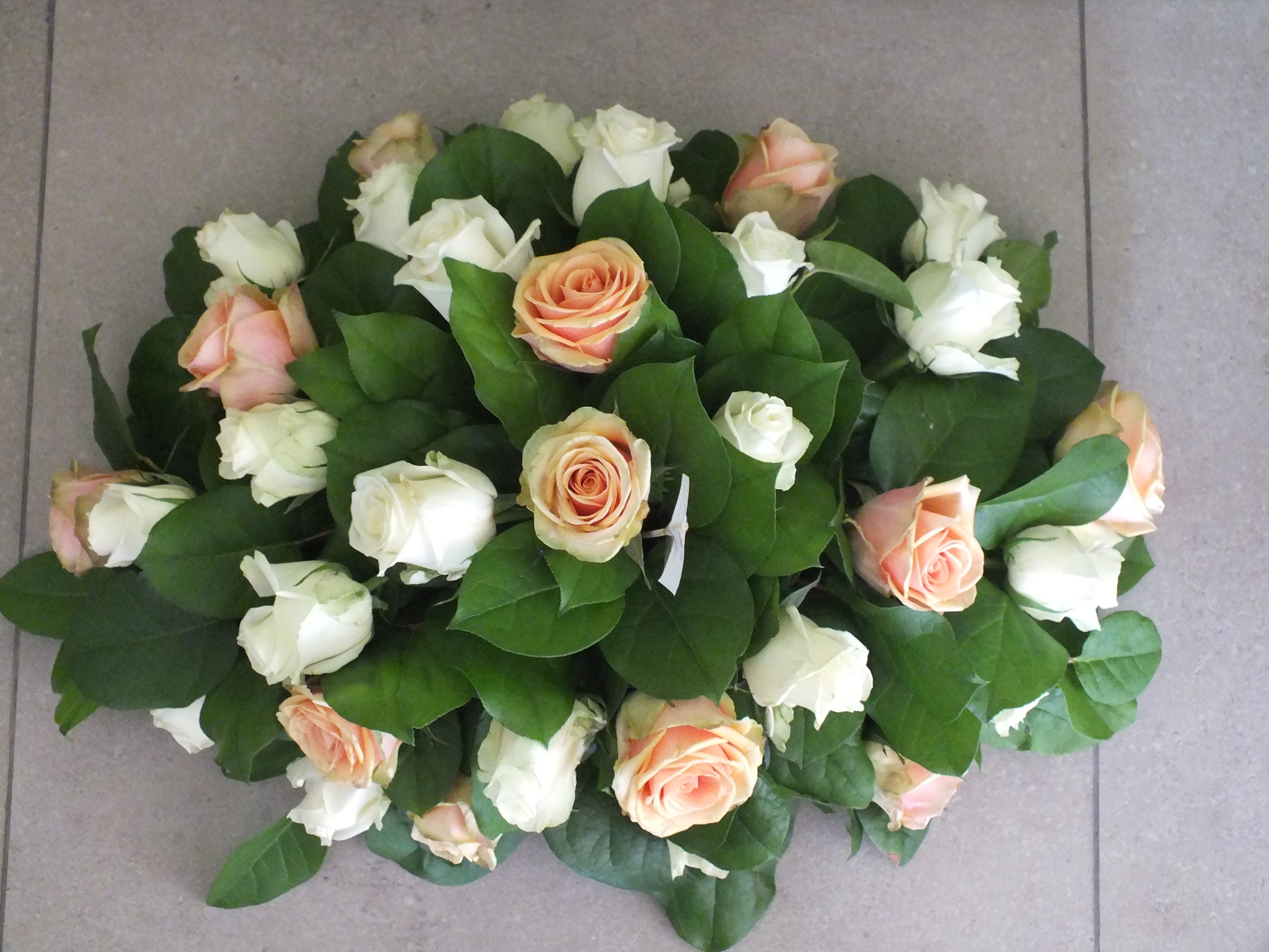 Nr 56 ovaal bloemstuk met witte en zalmkleurige rozen en groen